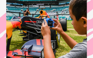 graphic for a press release - a child takes a photo of a Formula 1 car